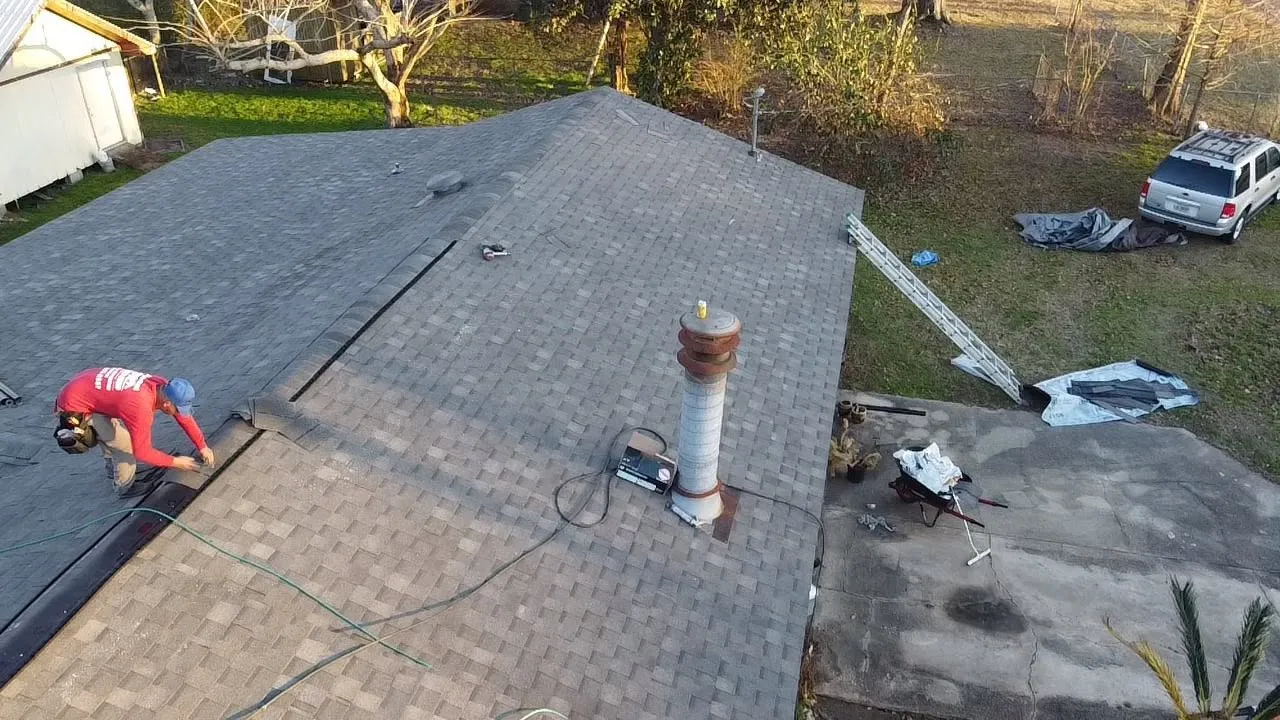 Roofer sealing shingles around a plumbing vent pipe