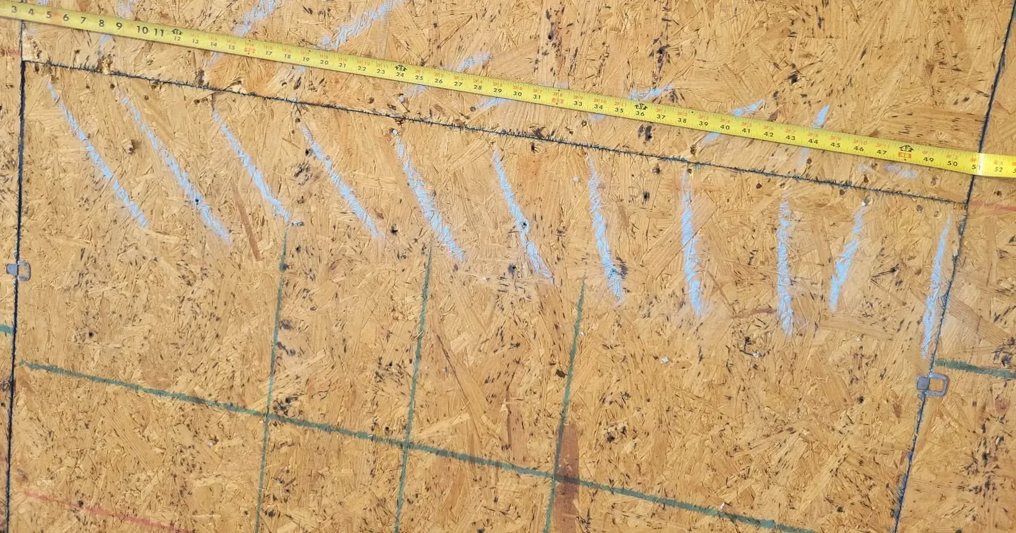 New plywood roof decking marked with chalk lines