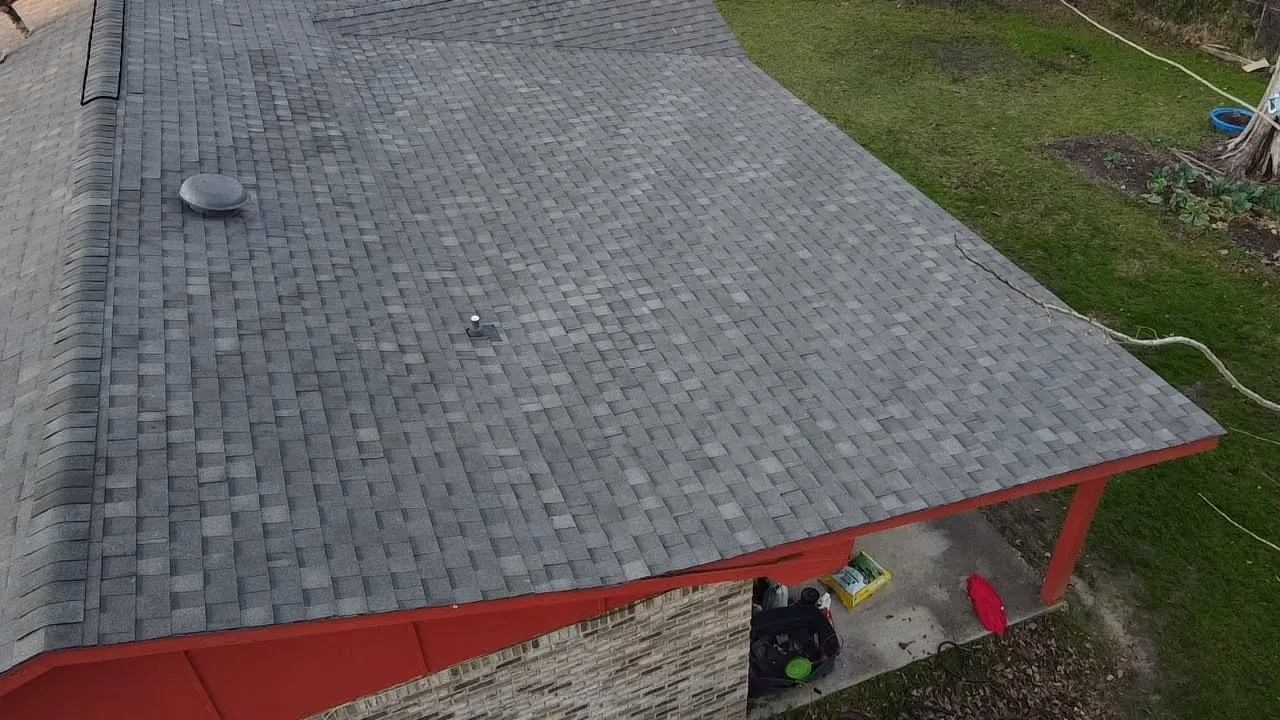 Overhead view of a new gray shingle roof with red trim