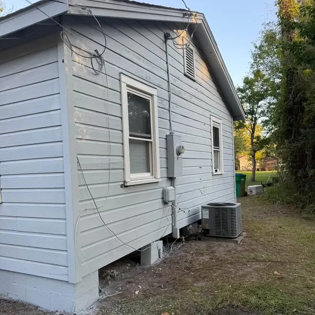 New gray vinyl siding along the side of a raised home