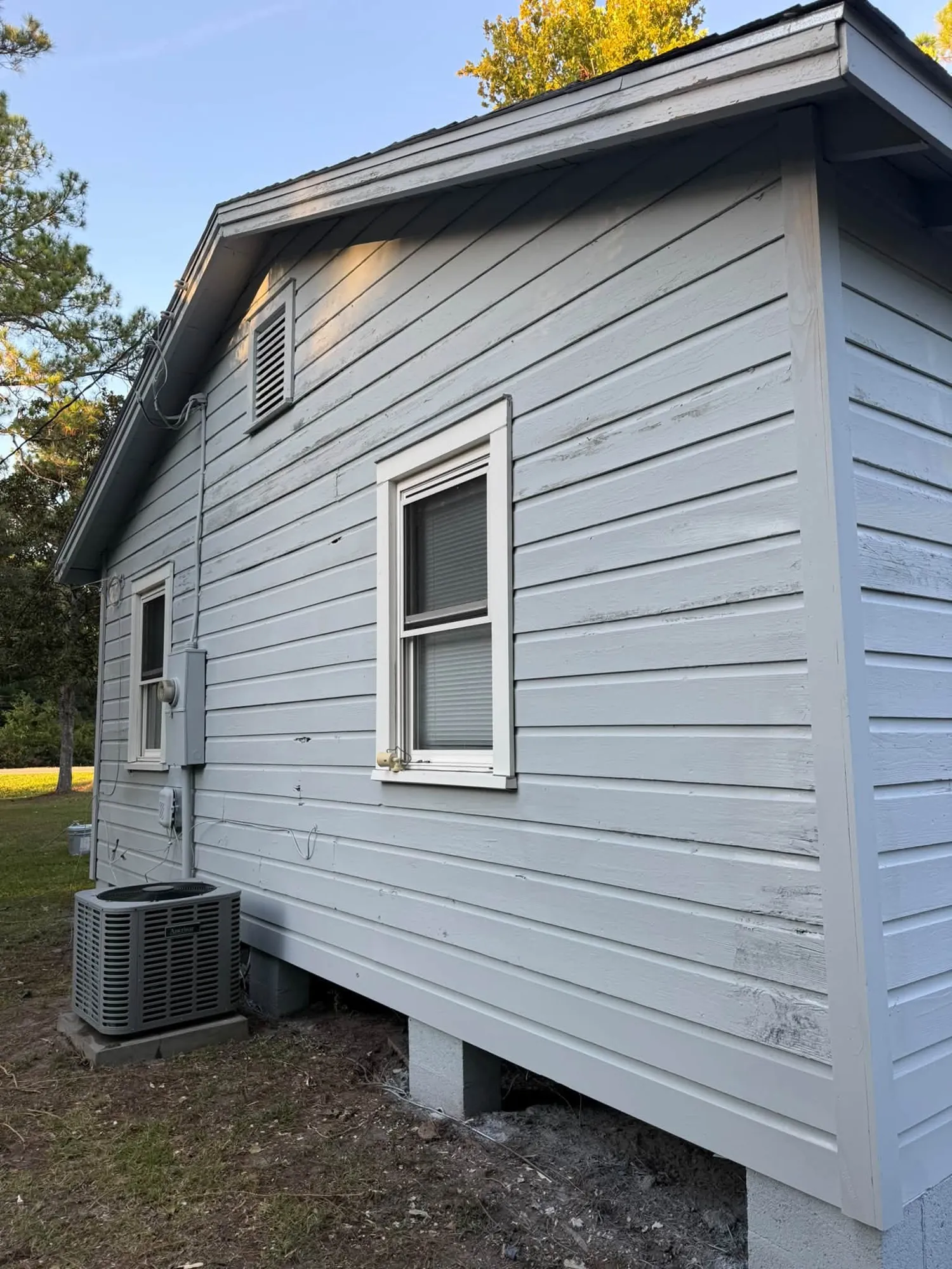 Gray vinyl siding trimmed around a window