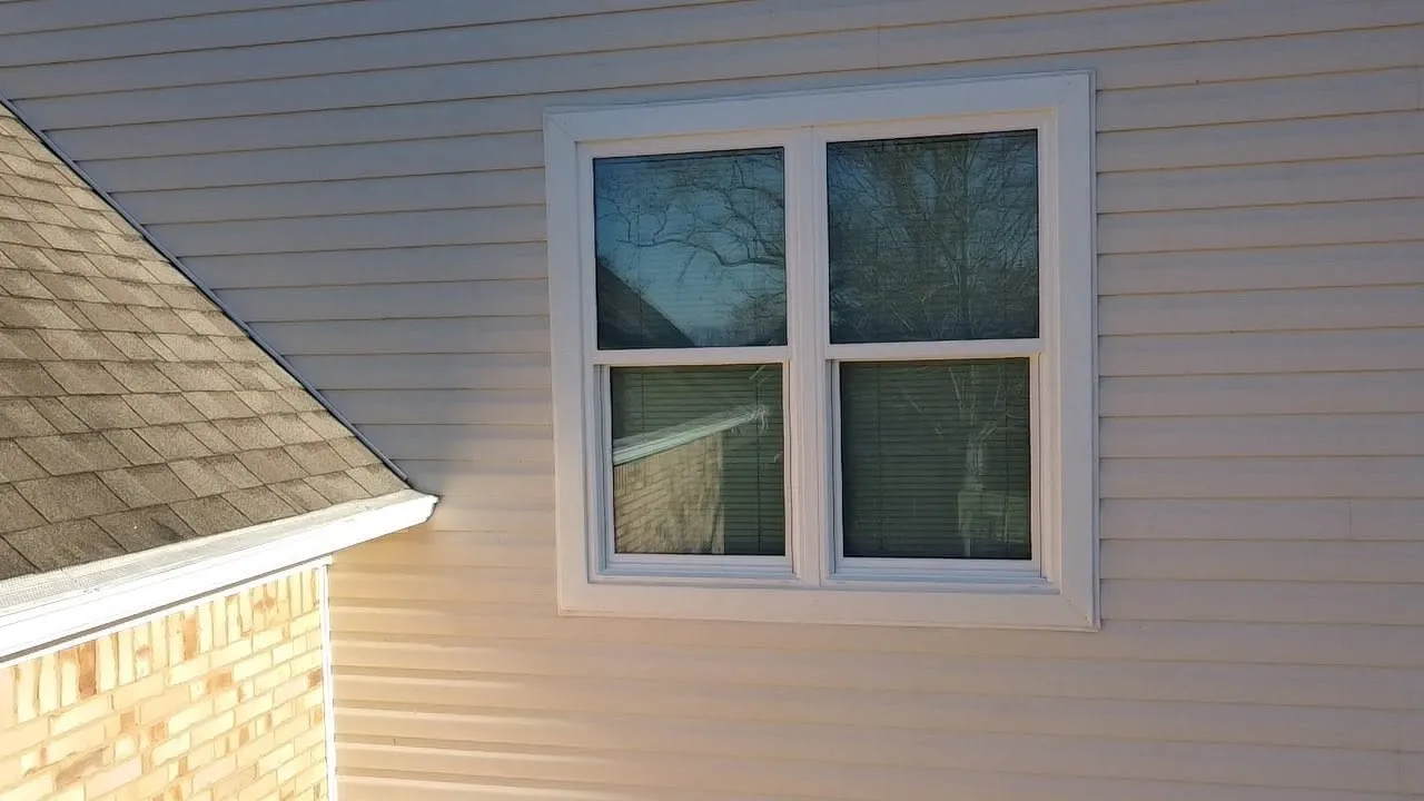 New vinyl siding meeting a shingle roofline
